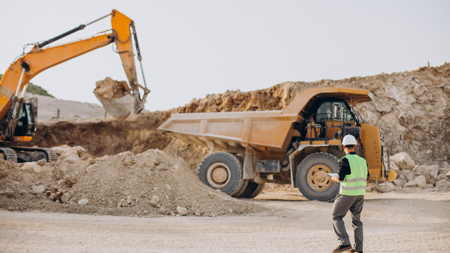 Excavator digging on a rocky jobsite in Midland, Texas