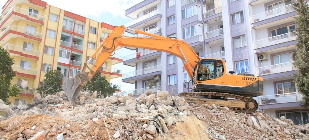 Excavator digging through dirt in San Antonio, TX jobsite