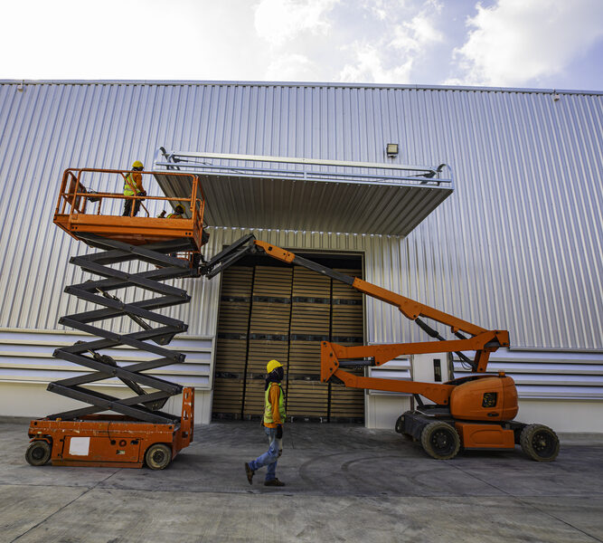 Scissor lift being used for exterior finishing on a commercial site in Arlington, Texas