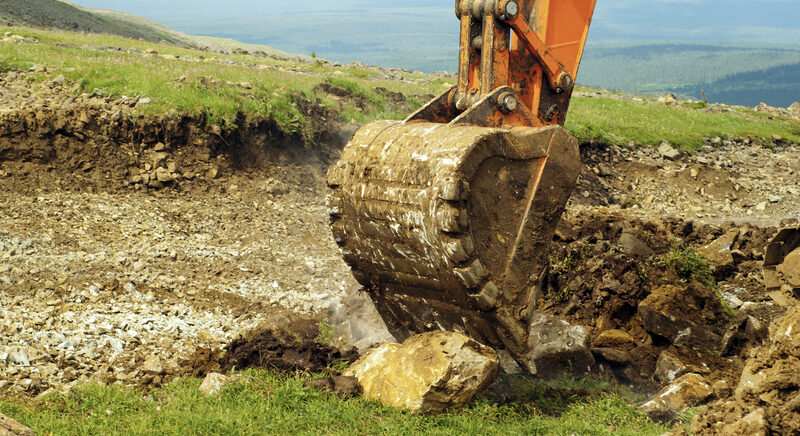 Excavator grading land for a foundation at a construction site in Wichita Falls, Texas