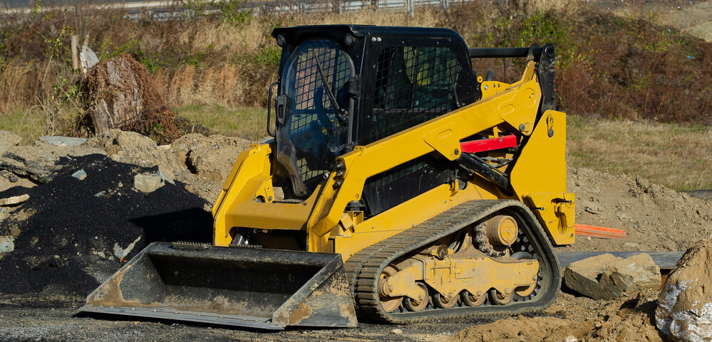 Skid steer loader operating at a commercial construction site in downtown Dallas, TX