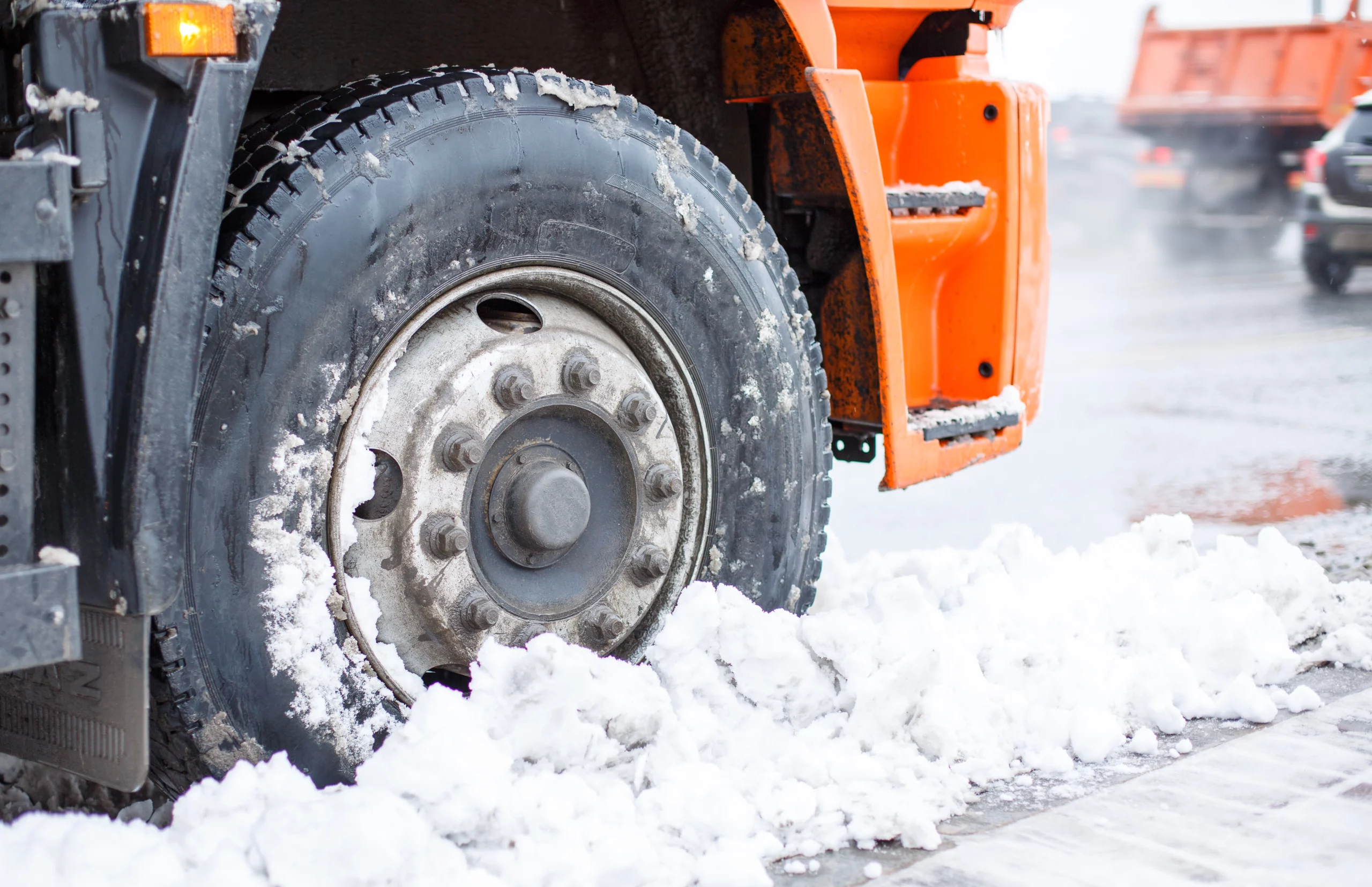 heavy-duty truck tire partially covered in snow