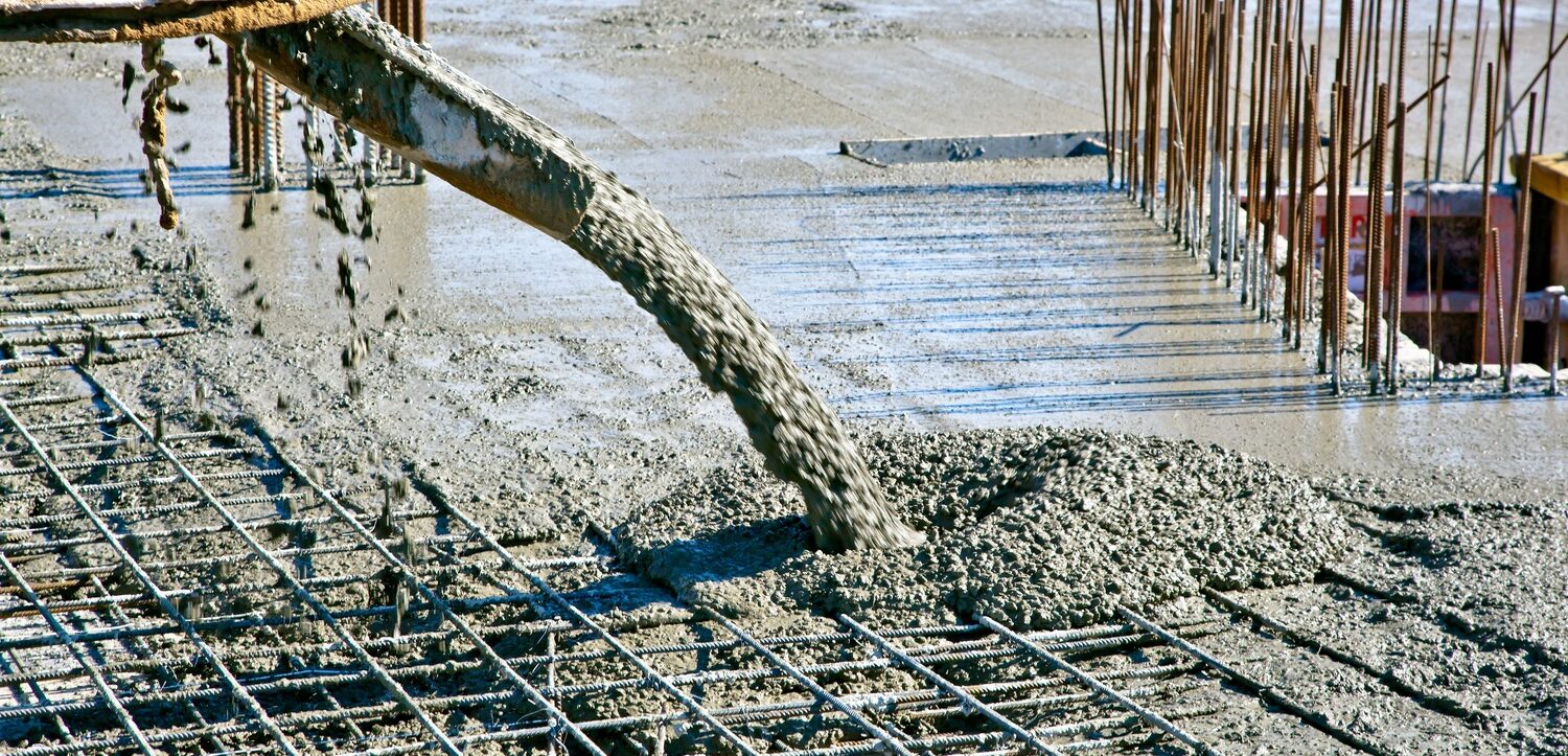 Concrete mixer truck pouring concrete on a commercial construction site.