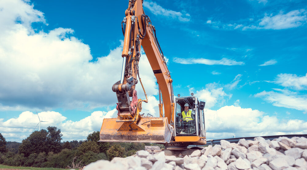 Heavy machinery operating at a job site with clear skies, representing peak summer construction season in USA 